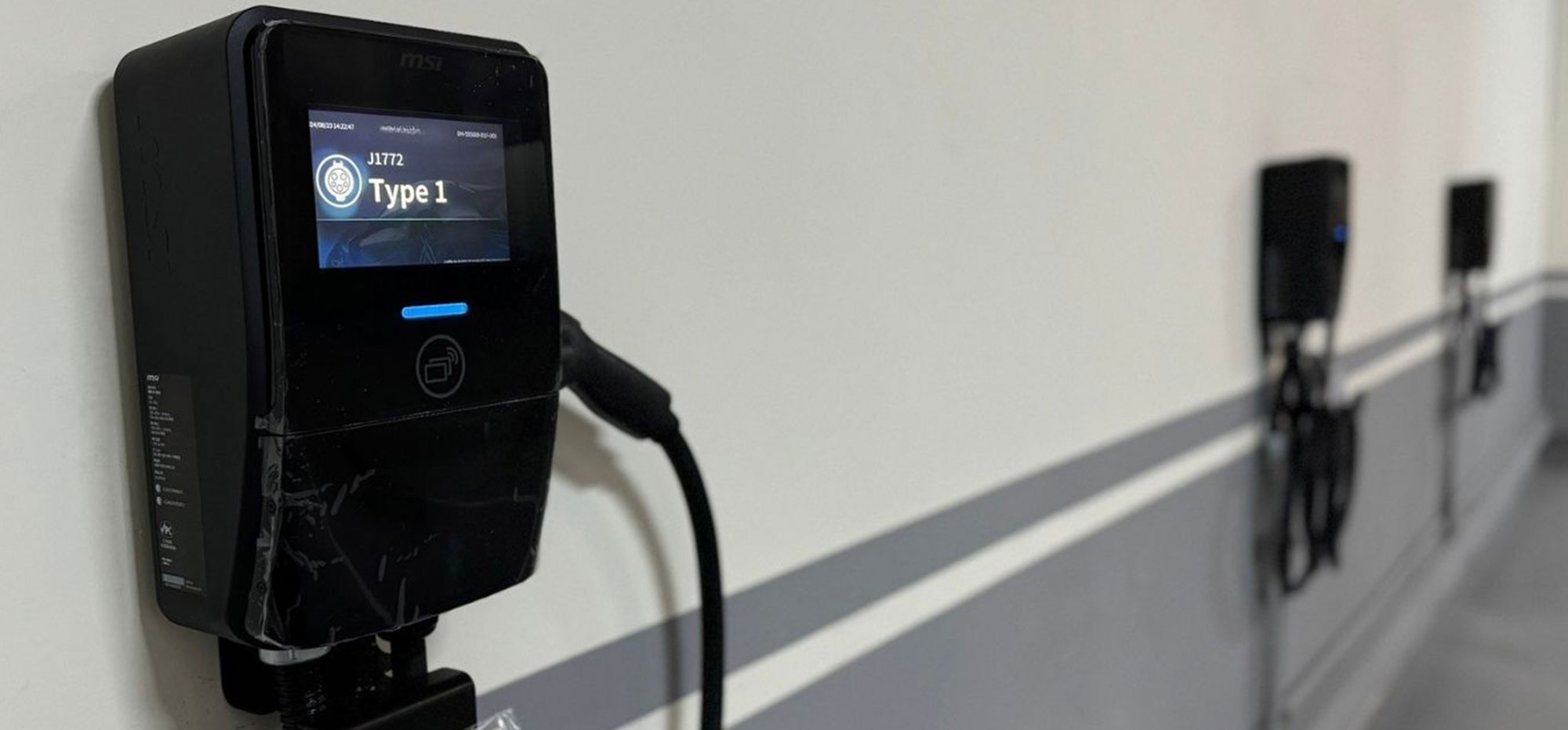 A long bank of installed MSI EV chargers in a parking lot with load management setup.