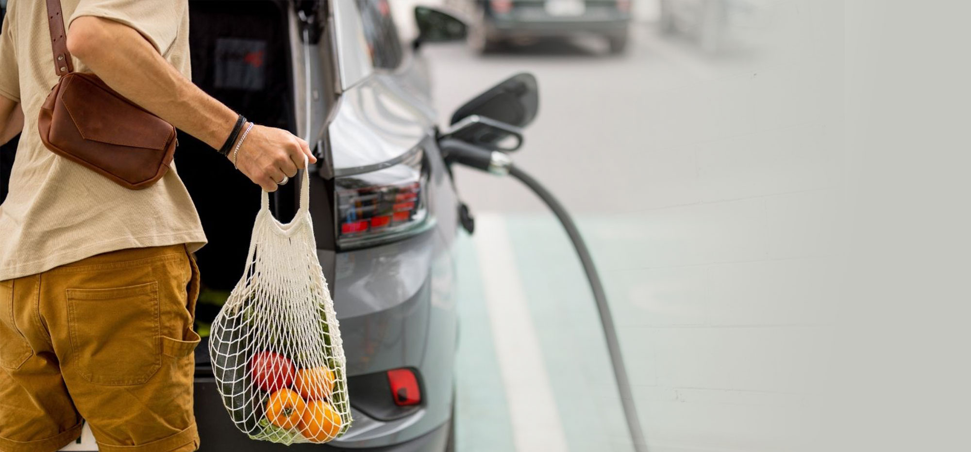 Customer returning to a charged-up EV after shopping at a local grocery store
