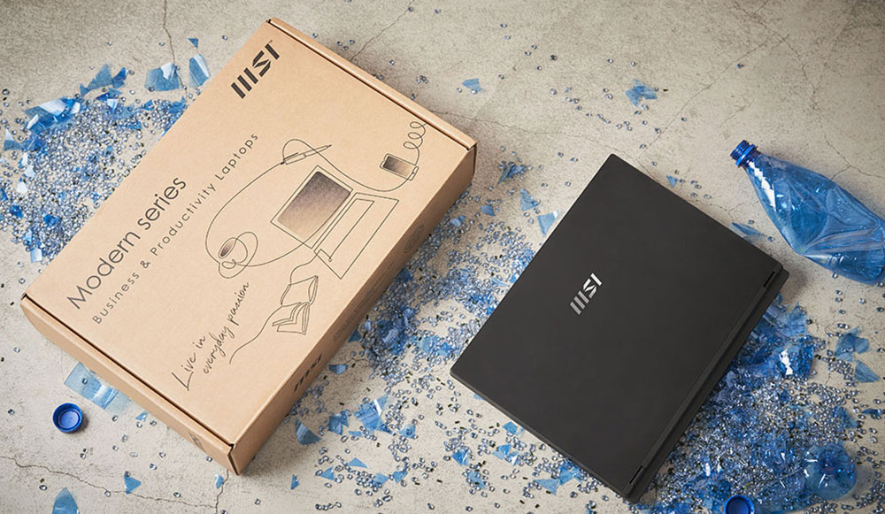 A laptop next to its packaging box, with recyclable glass and plastic bottles placed nearby, highlighting the product's environmentally-conscious manufacturing process.