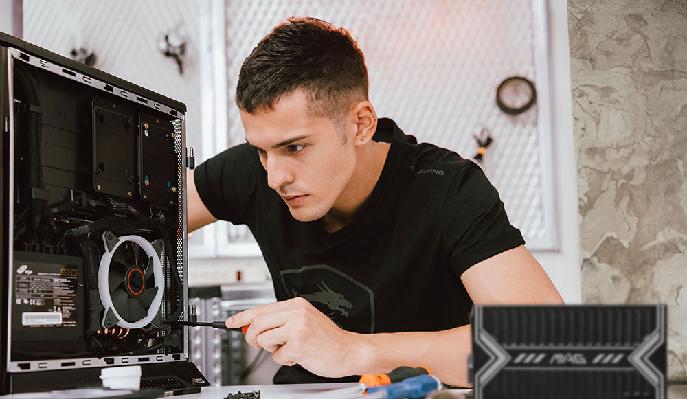 A man carefully screwing in the back panel of a business desktop PC, emphasizing customizable hardware installation and flexible expansion options.