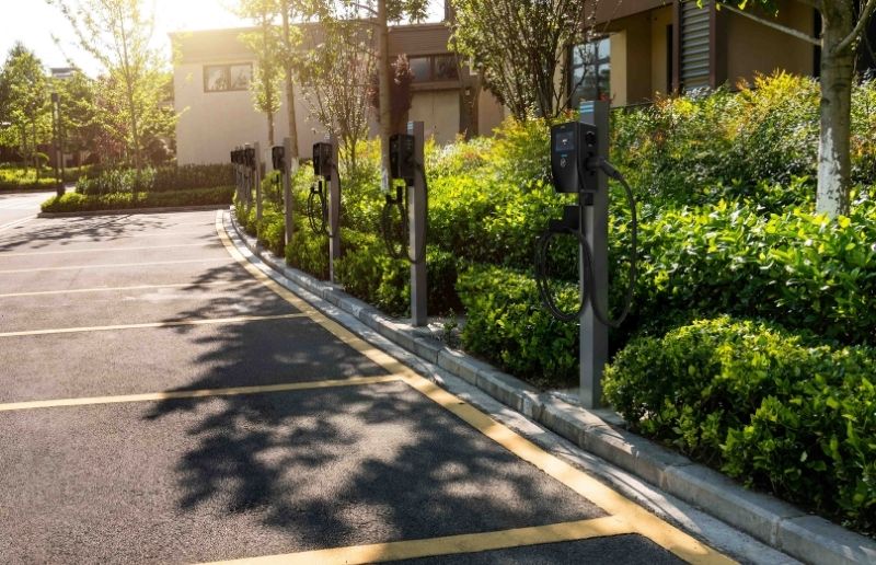 Row of commercial EV chargers installed in a landscaped parking lot