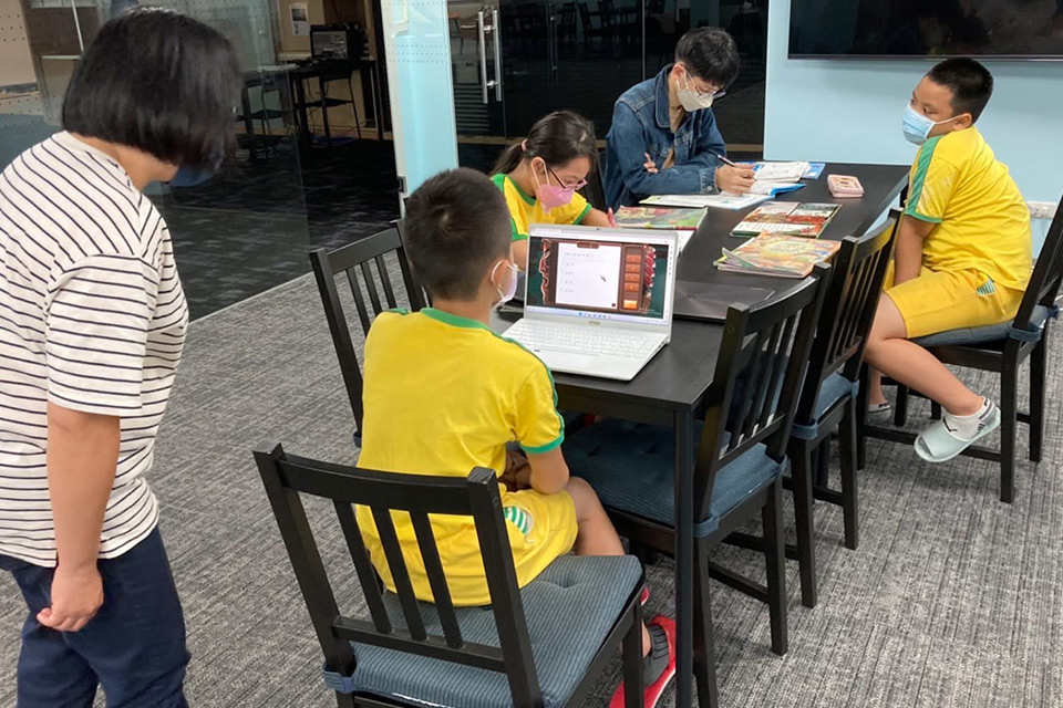 Schüler, die Laptops verwenden, um Fragen zu beantworten und während eines Nachmittagsprogramms auf der PaGamO Literacy Learning Platform zu interagieren